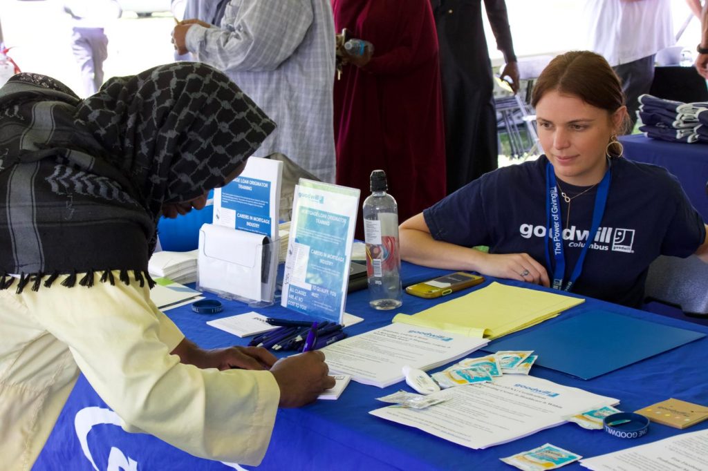 A community member speaking with a Goodwill Columbus representative at a resource fair